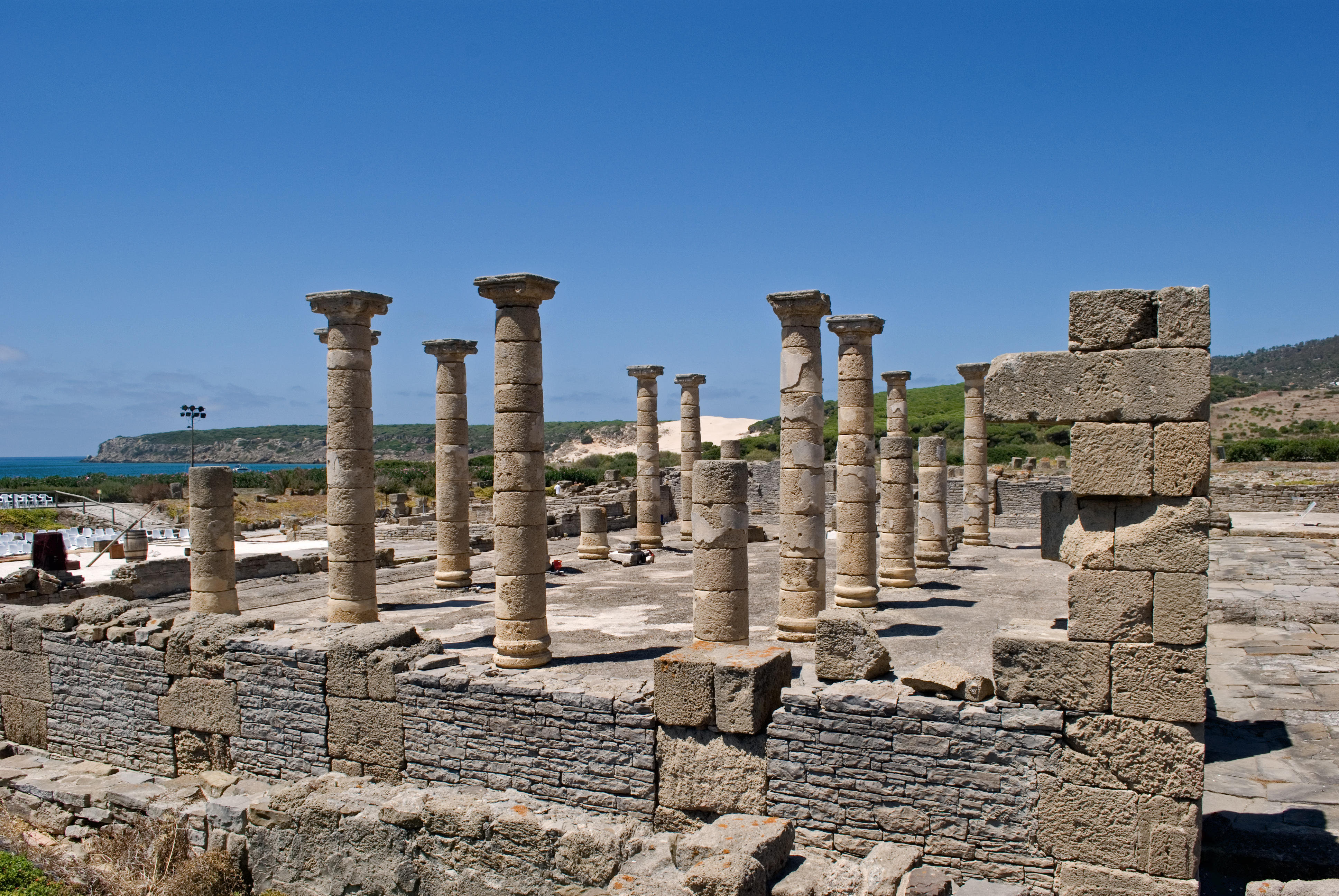 Roman ruins of Baelo Claudia near Bolonia Beach in Tarifa, with ancient stone columns and coastal landscape in the background