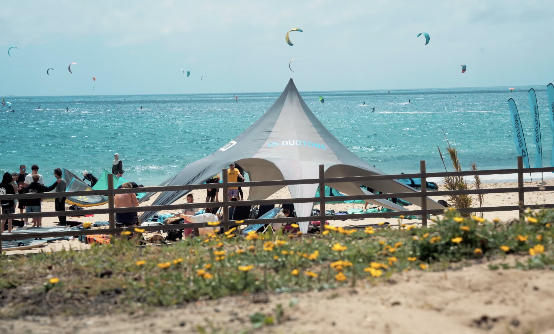 Duotone demo day tent on Valdevaqueros Beach in Tarifa with riders testing the latest kitesurfing gear in front of Liam Whaley Pro Center