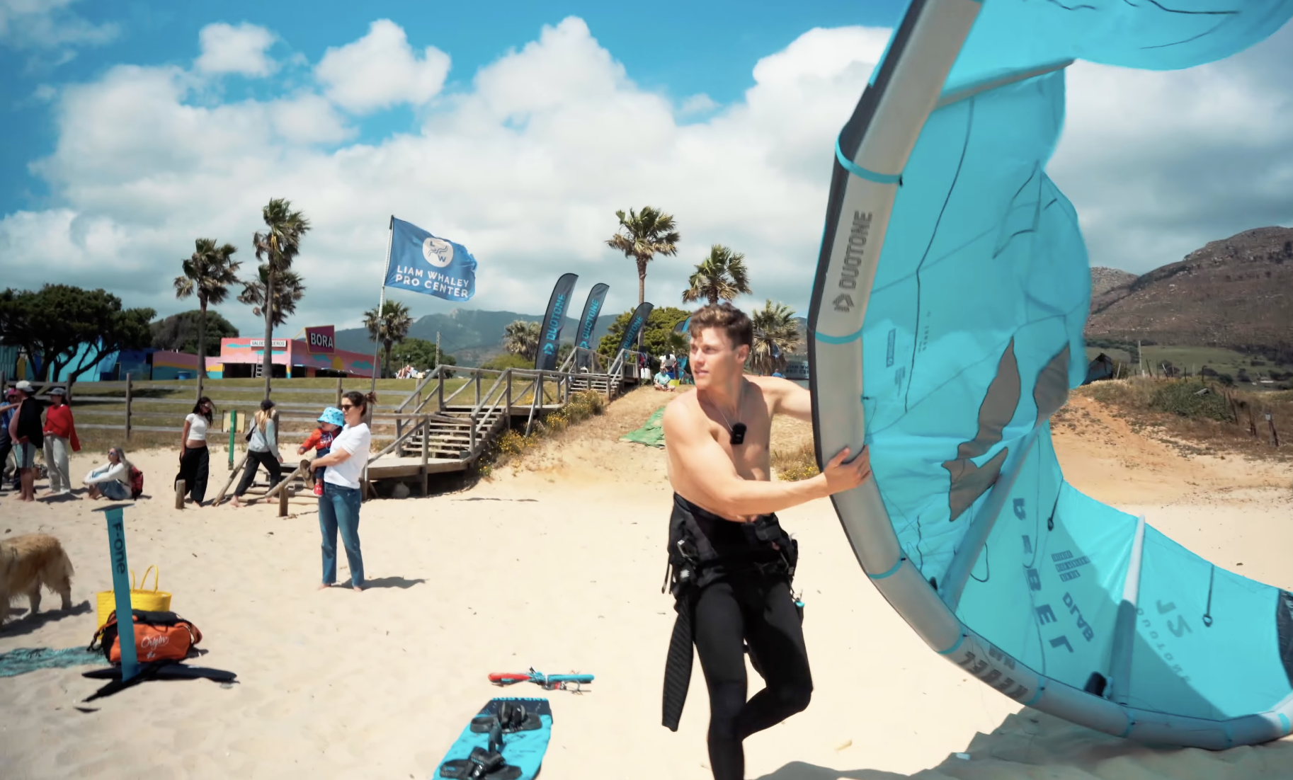 Liam Whaley carrying a Duotone Rebel D/LAB kite during a Duotone demo day at Valdevaqueros Beach in Tarifa