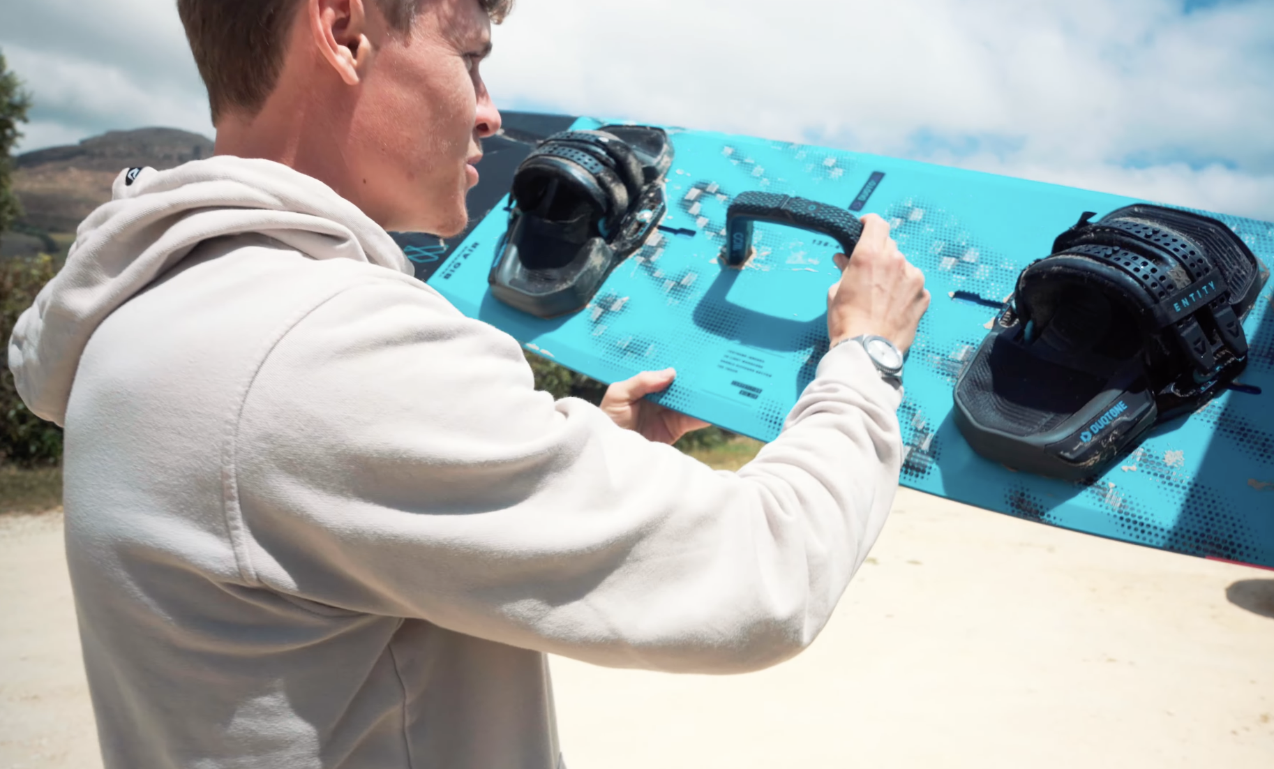 Liam Whaley showing the Duotone Team Series Big Air board with integrated Woo handle during a gear demo in Tarifa