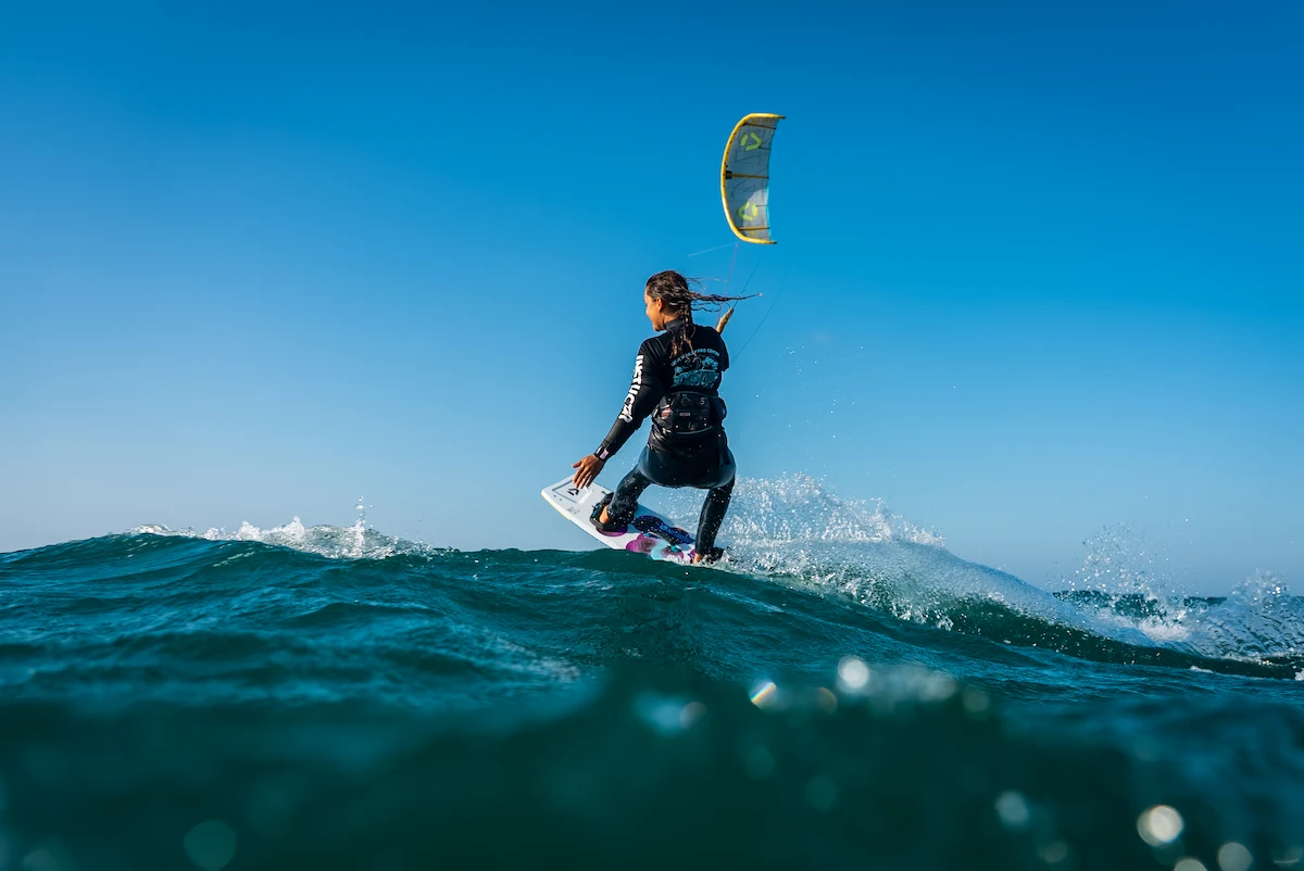 A kitesurfer is having a fun session in tarifa in front of Liam Whaley pro center