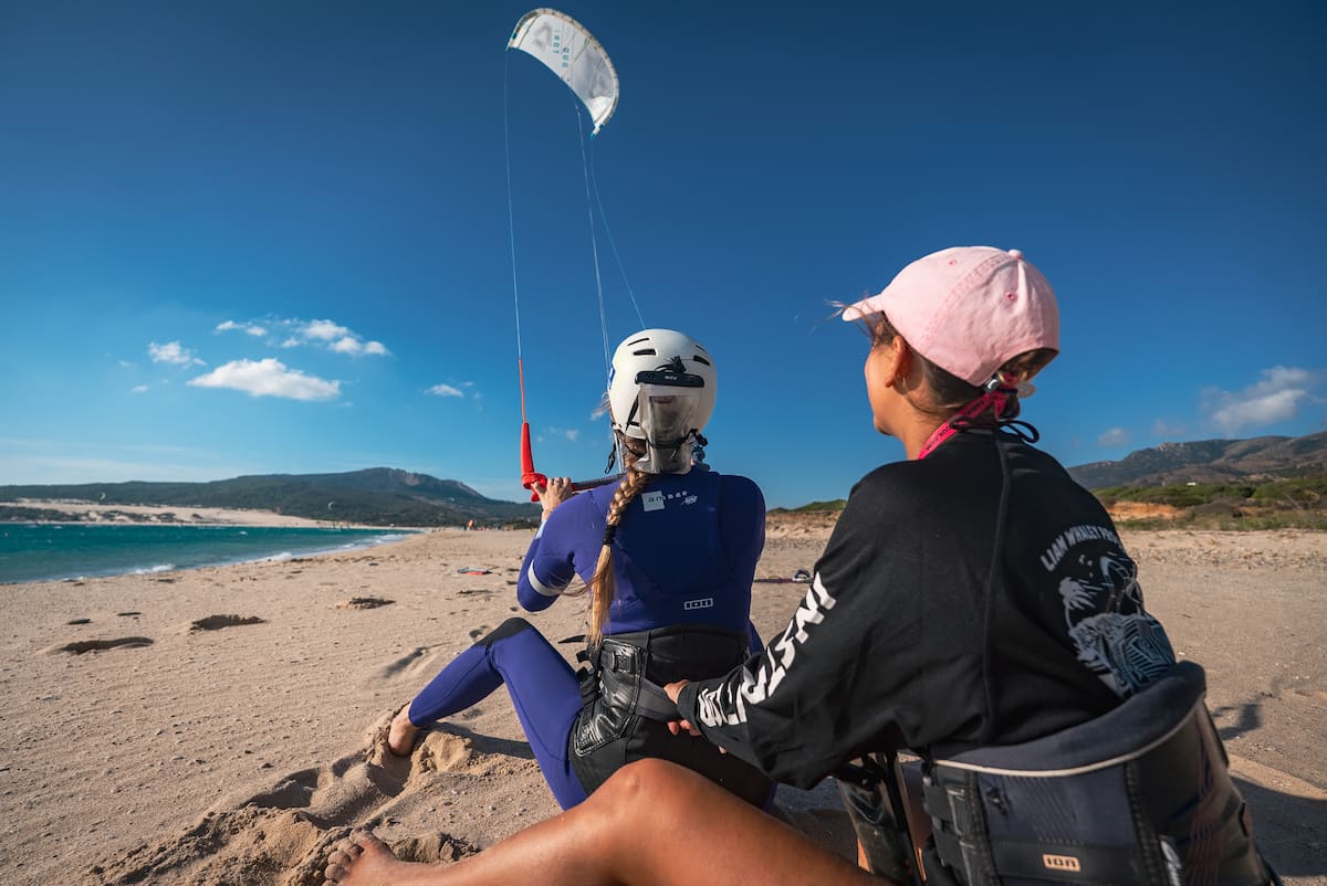 Kitesurfing lesson in Tarifa with instructor assisting beginner at Valdevaqueros Beach