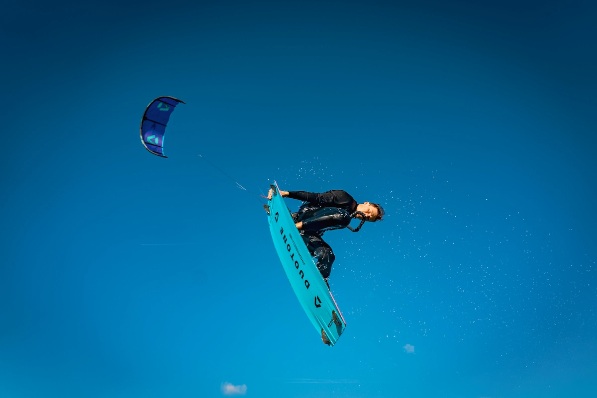 Advanced kitesurfer performing a jump in Tarifa with Duotone kite and board during strong spring wind conditions