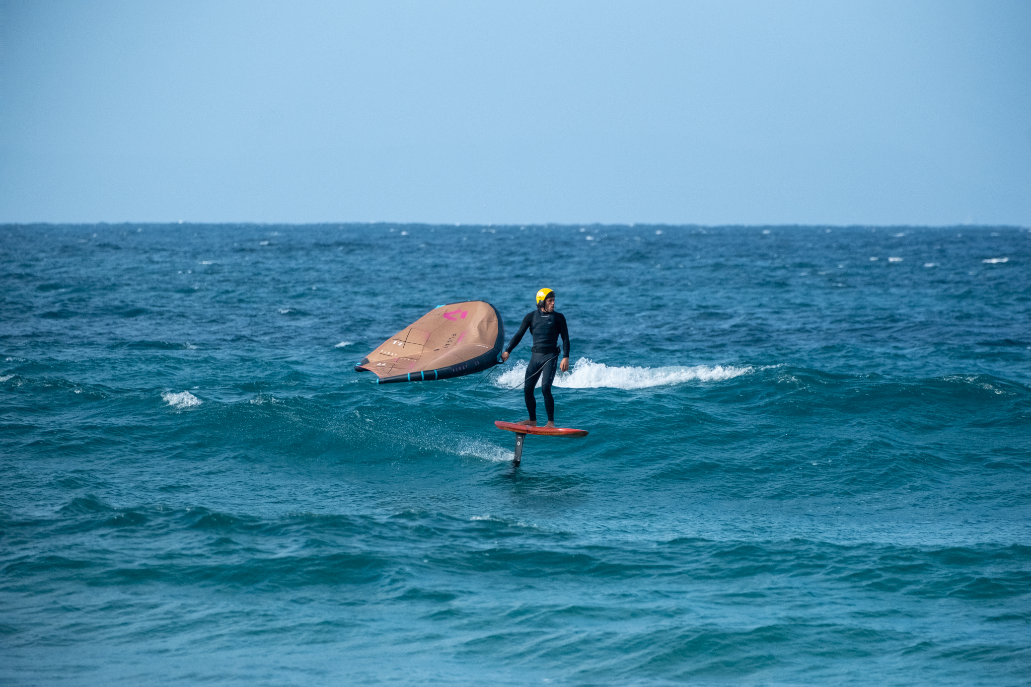 Wingfoil rider practising a controlled foil flight during wingfoil progression in Tarifa