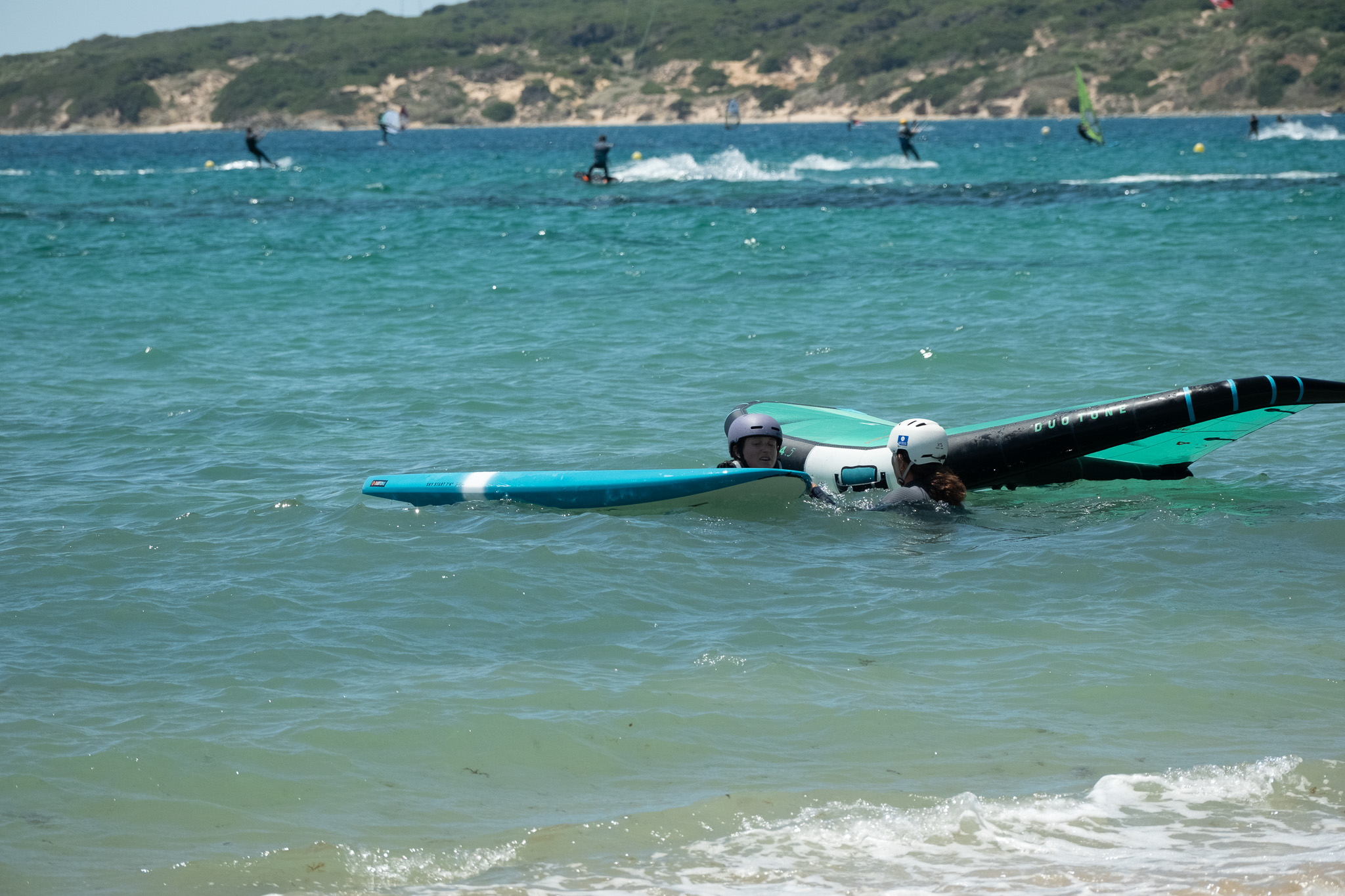 Child with instructor during a beginner wingfoil lesson at Valdevaqueros, Tarifa
